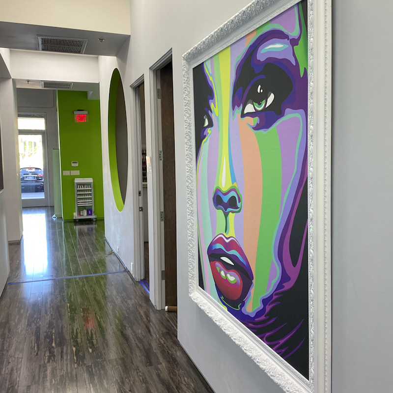 A hallway with a large painting of a woman 's face.