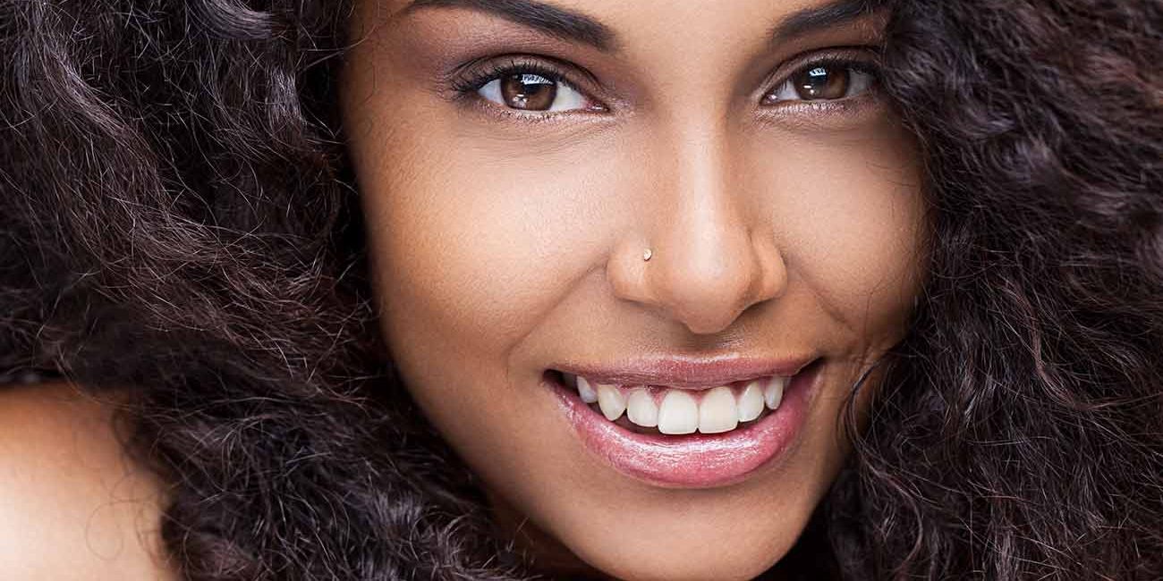 A woman with long hair is smiling for the camera.