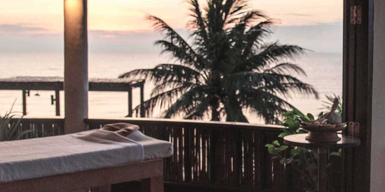 A table and chairs in front of an ocean view.