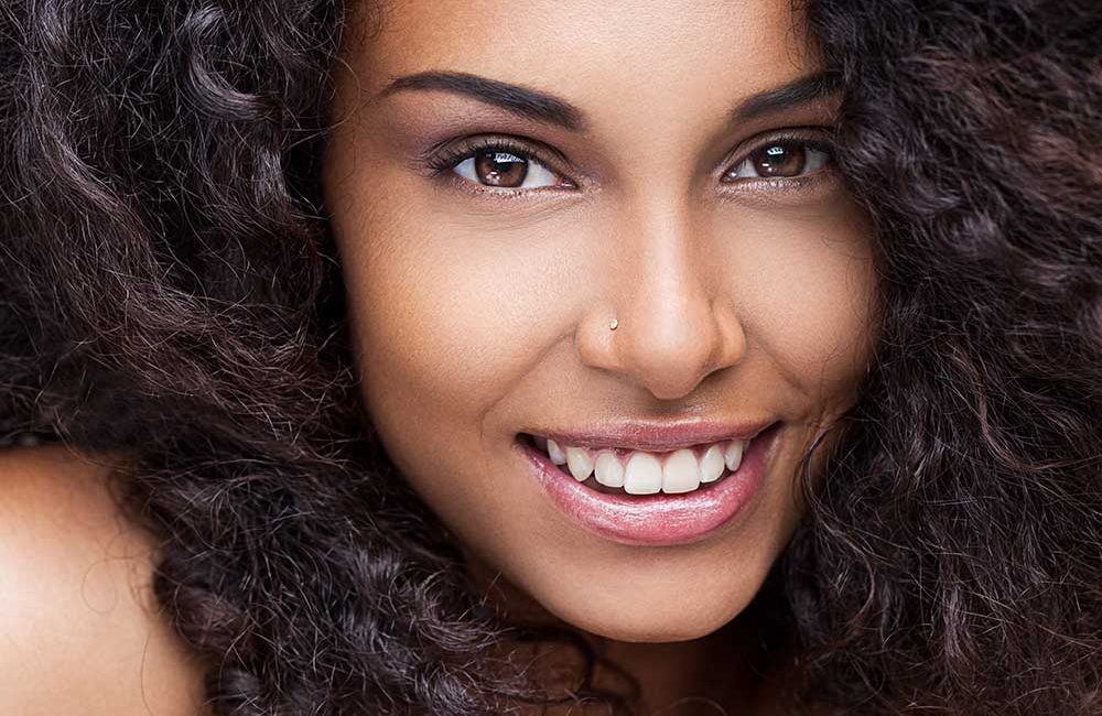 A woman with long hair is smiling for the camera.