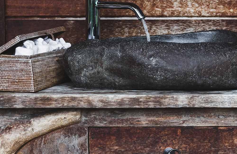 A sink with a bottle of wine on it