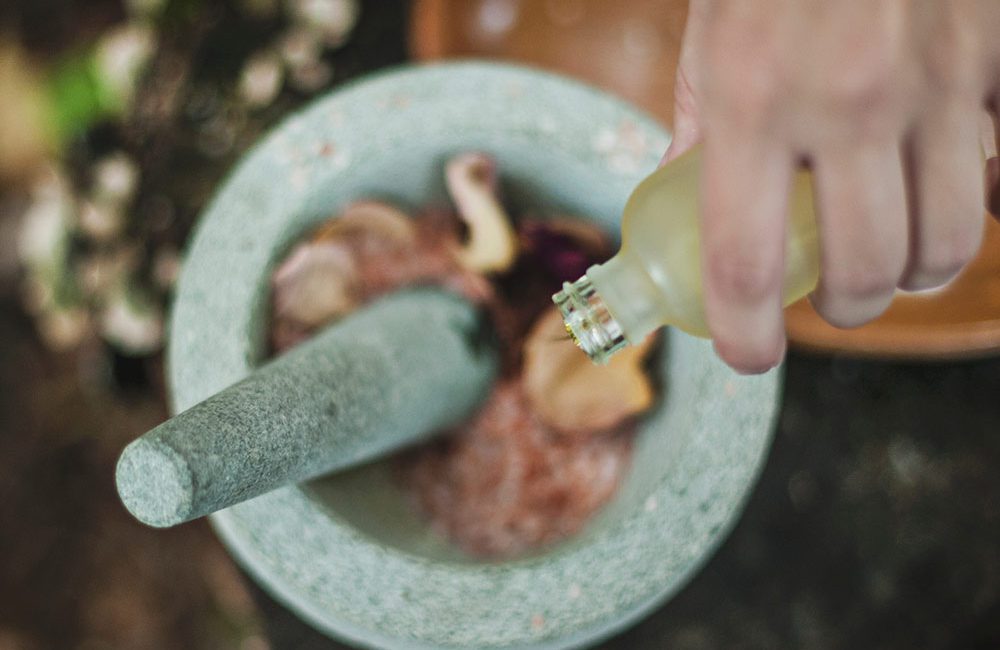 A person is using a mortar and pestle to grind food.