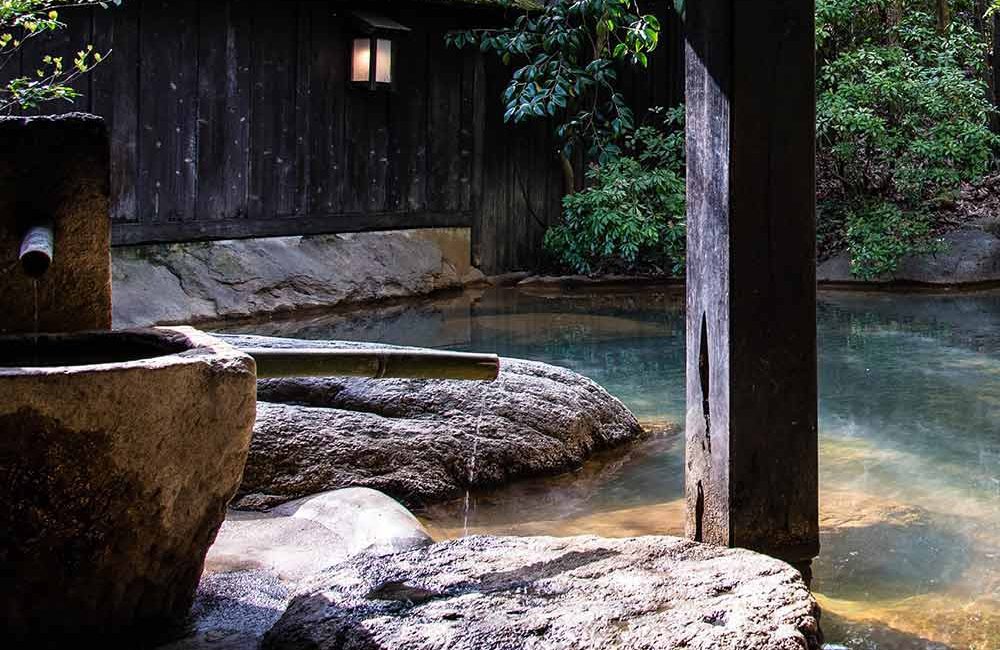 A stone fountain in the middle of a river.