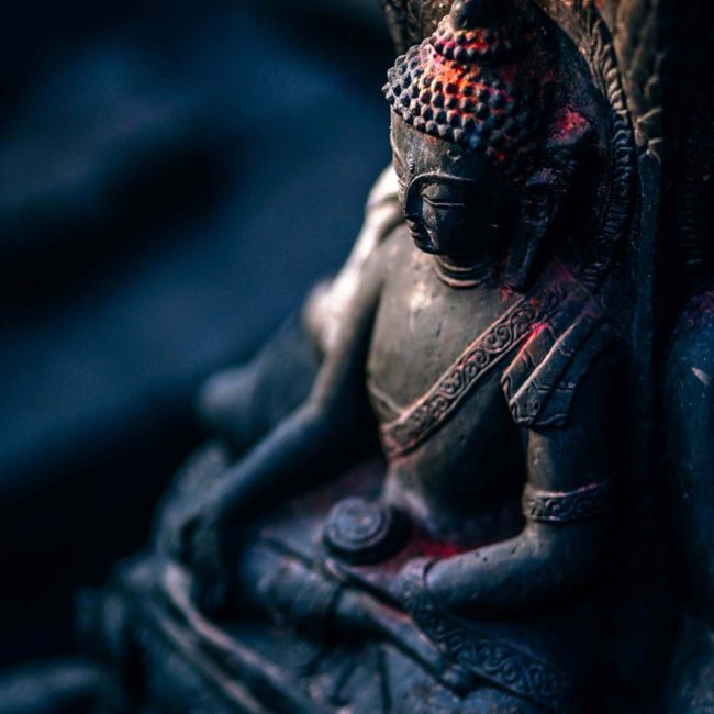 A statue of buddha sitting in the dark.