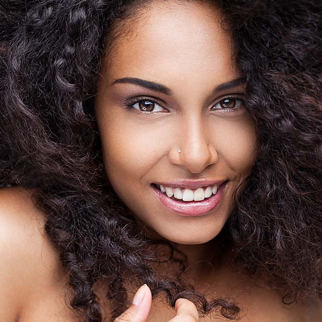 A woman with long hair is smiling for the camera.