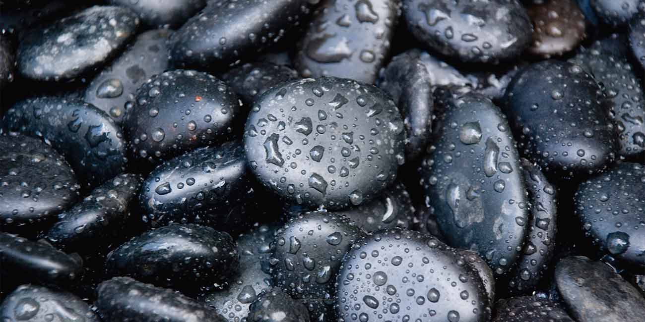 A close up of water drops on some rocks